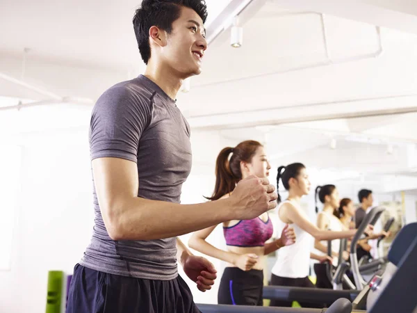 Asian young people working out on treadmill — Stock Photo, Image