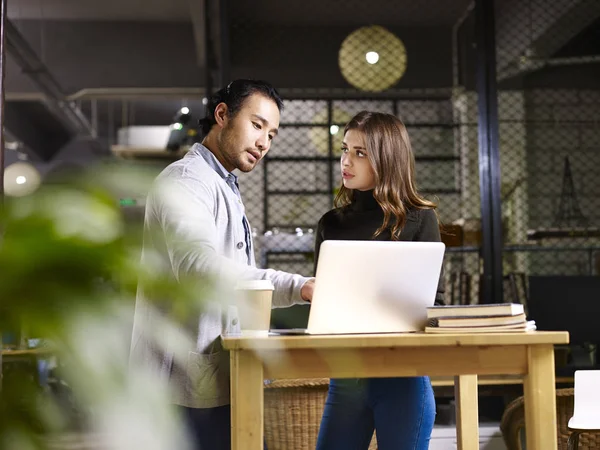 Asiatischer Geschäftsmann und kaukasische Geschäftsfrau reden im Büro — Stockfoto