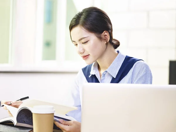 Jeune femme d'affaires asiatique travaillant au bureau en regardant des notes — Photo