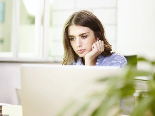 Jonge Kaukasische zakenvrouw werkzaam in kantoor — Stockfoto