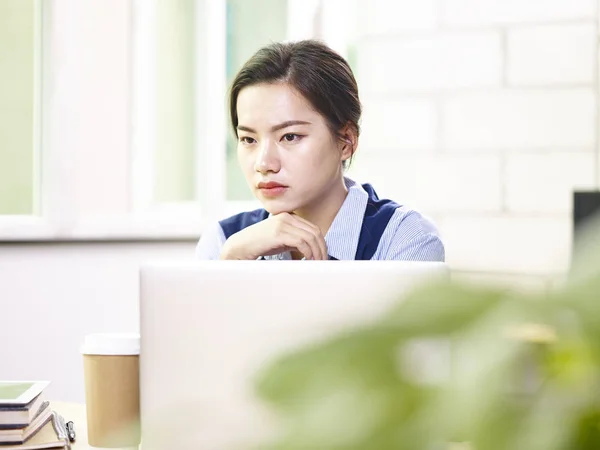 Contemplando joven asiática mujer de negocios trabajando en oficina — Foto de Stock