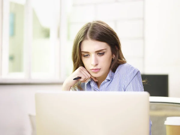 Jonge Kaukasische zakenvrouw werkzaam in kantoor — Stockfoto