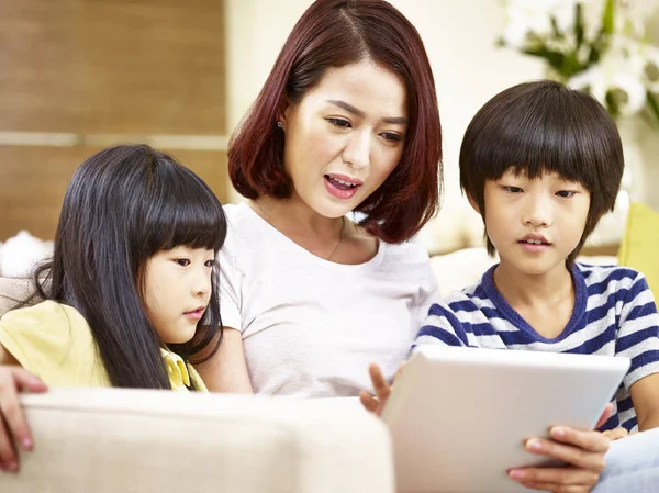 アジアの母と 2 人の子供が一緒にデジタル タブレットを使用して — ストック写真