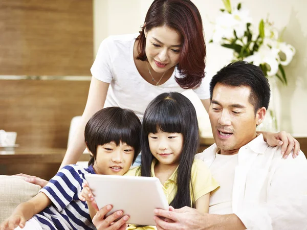 함께 디지털 태블릿을 사용 하 여 두 아이 들과 함께 아시아 가족 — 스톡 사진