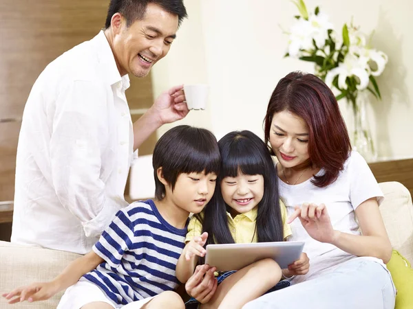 Asiática família com duas crianças usando tablet digital juntos — Fotografia de Stock