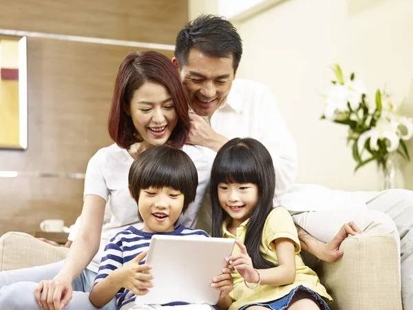 Asya aile, iki çocuklu dijital tablet birlikte kullanma — Stok fotoğraf