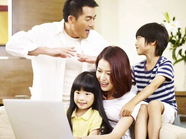 Asian family with two children using laptop computer together — Stock Photo, Image