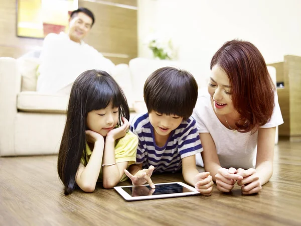 Asya anne ve iki çocuğu dijital tablet birlikte kullanma — Stok fotoğraf