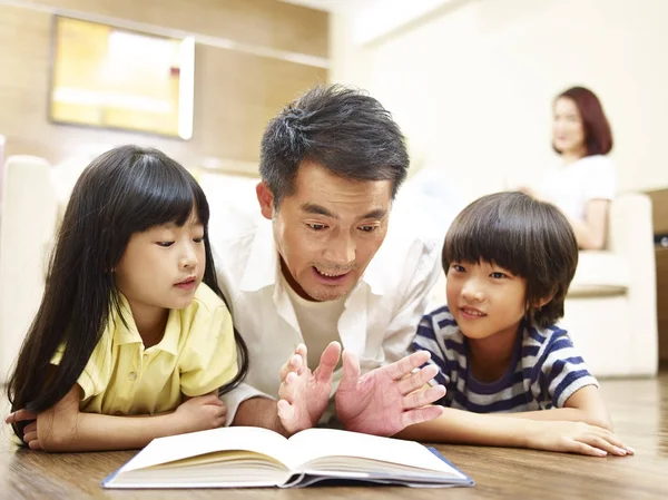 Padre asiático leyendo libro contando historia a dos niños — Foto de Stock