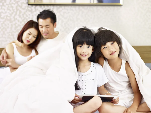 침실에 재미 두 아이 함께 아시아 가족 — 스톡 사진