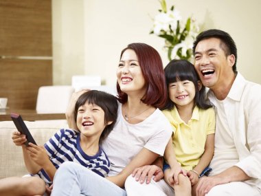İki çocuklu evde Tv izlerken Asya aile