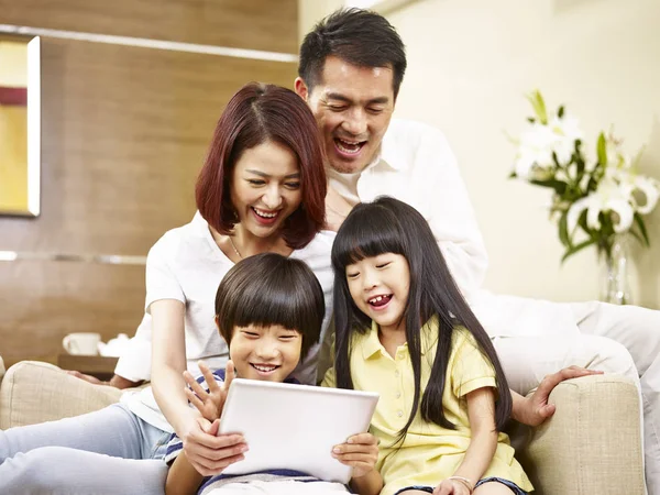 Asiática família com duas crianças usando tablet digital juntos — Fotografia de Stock