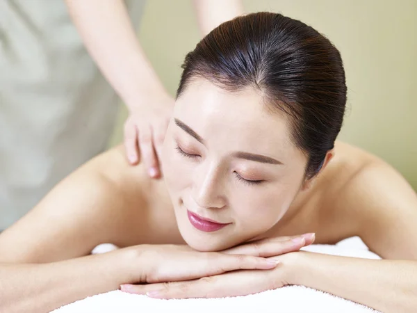 Schöne junge asiatische Frau erhalten Massage im Wellness-Salon — Stockfoto