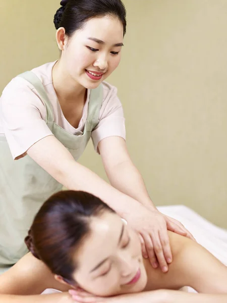 Joven asiático masajista realizar masaje en mujer — Foto de Stock
