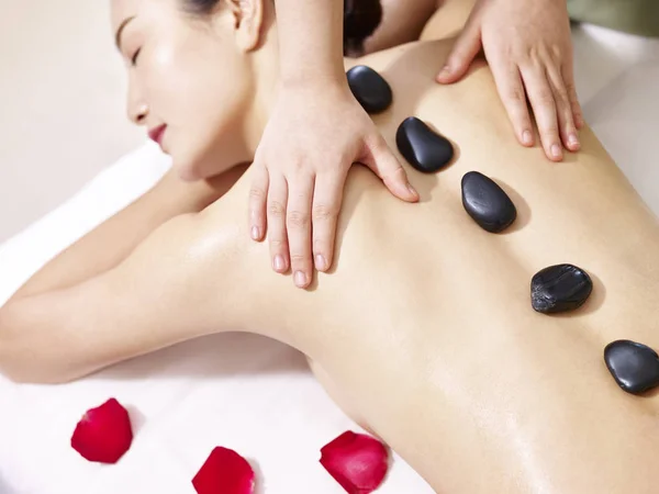 Junge asiatische Frau erhält Hot Stone Massage im Wellness-Salon — Stockfoto