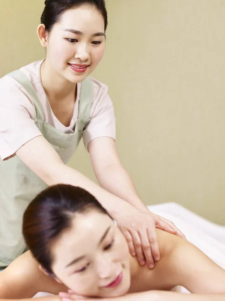 Jovem asiático massagista realizando massagem na mulher — Fotografia de Stock