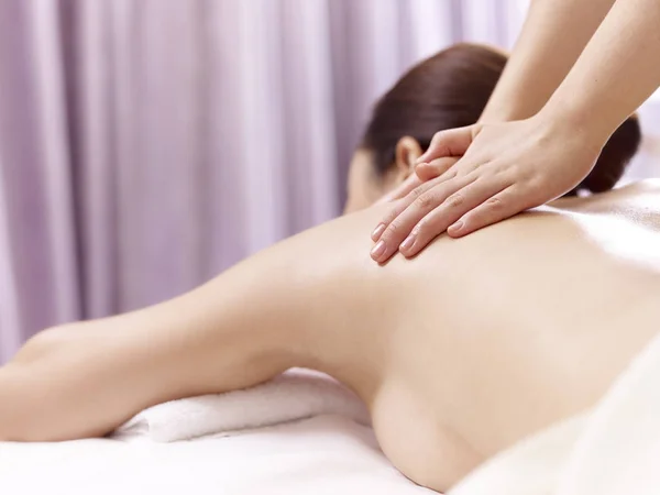 Hände von Masseur Durchführung von Massage auf junge asiatische Frau — Stockfoto