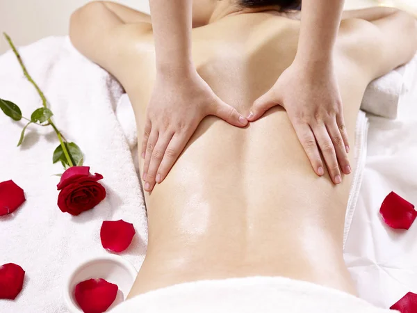 Las manos del masajista realizando el masaje sobre el cuerpo de la mujer joven —  Fotos de Stock