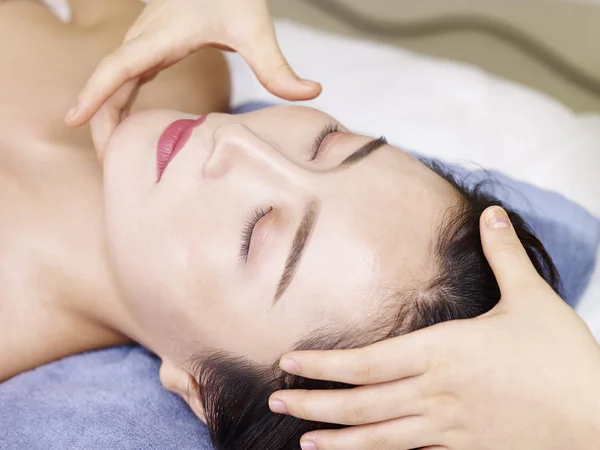 Joven asiático mujer recibiendo cara masaje en spa salon —  Fotos de Stock
