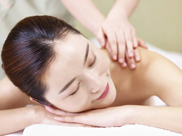Hermosa joven asiática mujer recibiendo masaje en spa salon — Foto de Stock