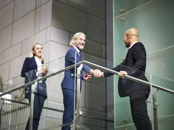 Ejecutivos corporativos estrechando la mano en el moderno edificio de oficinas — Foto de Stock