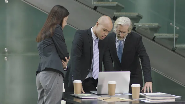 Trois dirigeants d'entreprise réunis dans un bureau moderne — Photo