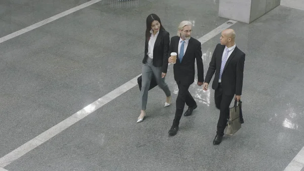 Ejecutivos corporativos caminando a través del vestíbulo del edificio de oficinas — Foto de Stock