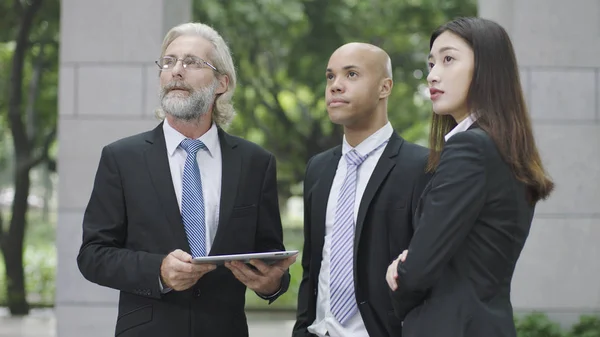 Tres ejecutivos corporativos mirando hacia arriba — Foto de Stock