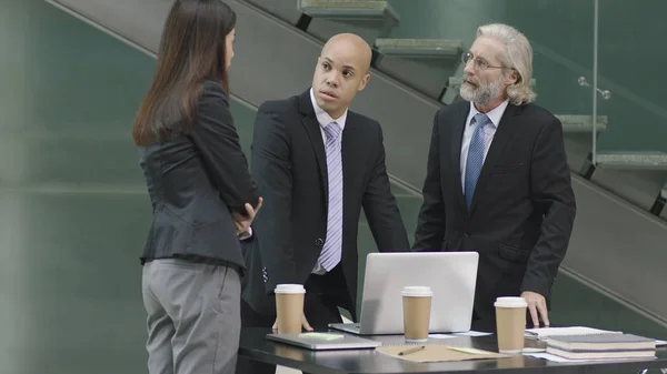Tres ejecutivos corporativos reunidos en una oficina moderna —  Fotos de Stock
