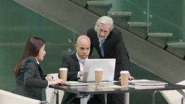 dizüstü bilgisayar kullanan office tartışırken iş toplantı üç şirket yöneticileri.