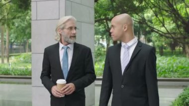 iki şirket iş adamları iş modern bina lobide yürürken tartışırken sohbet söz.