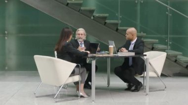 Şık modern ofis tartışırken iş toplantı üç çokuluslu şirket yöneticileri. 