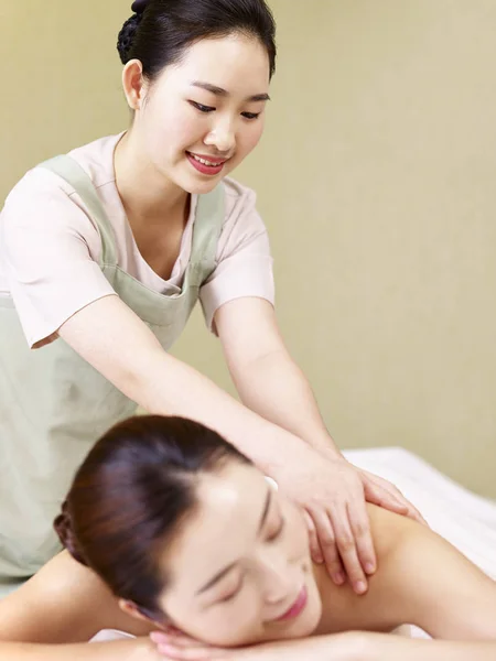 Jovem asiático massagista realizando massagem na mulher — Fotografia de Stock