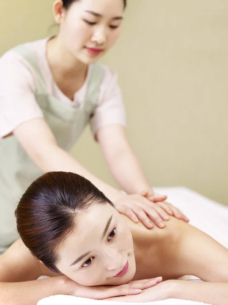 Hermosa joven asiática mujer recibiendo masaje en spa salon — Foto de Stock