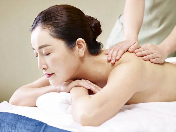 Mladá asijská žena příjem masáž ve spa salonu — Stock fotografie