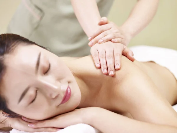 Beautiful young asian woman receiving massage in spa salon — Stock Photo, Image