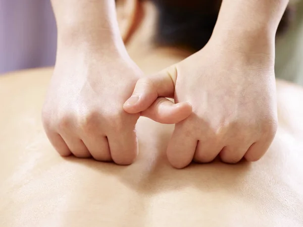 Mãos de massagista realizando massagem no jovem mulher asiática — Fotografia de Stock