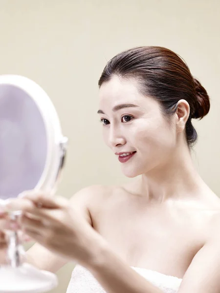 Mladá asijská žena dívá na sebe v zrcadle — Stock fotografie