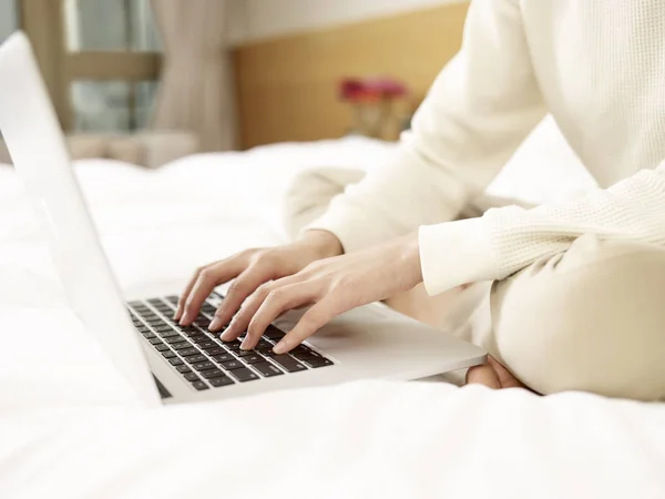 Asijská žena pomocí přenosného počítače na posteli — Stock fotografie