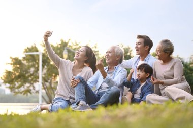 Mutlu Asyalı aile selfie çekiyor.