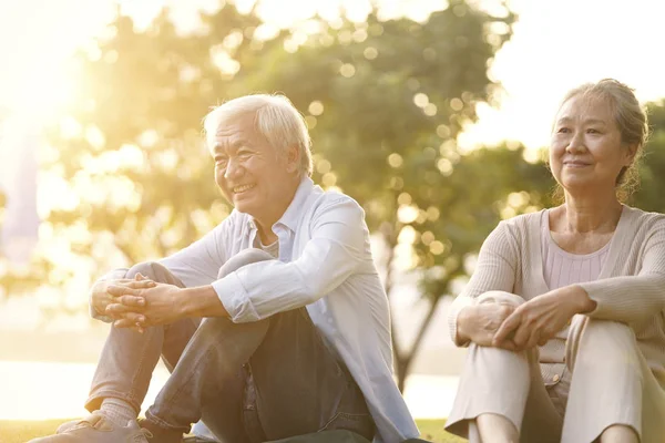 Asiatique senior homme et femme appréciant coucher de soleil dans parc — Photo