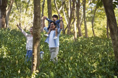 Asyalı aile ormanda eğleniyor.