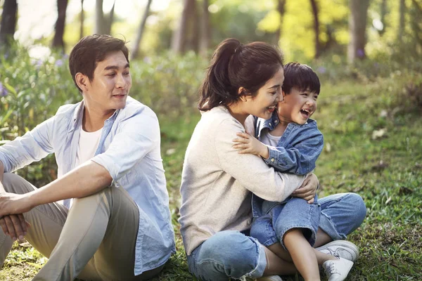 Asian family with one child relaxing in park — Stock Photo, Image