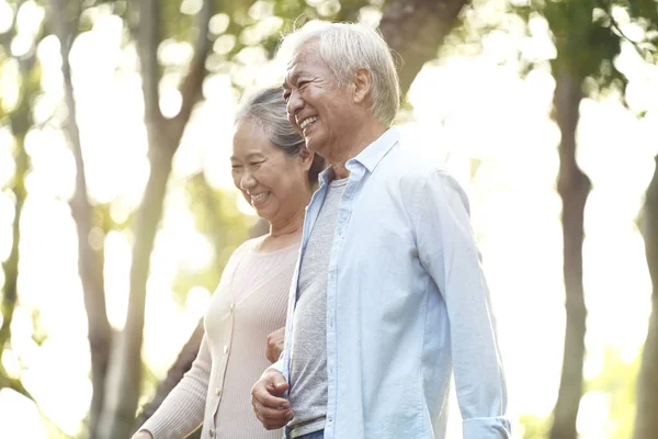 Старша азіатська пара гуляє в парку — стокове фото