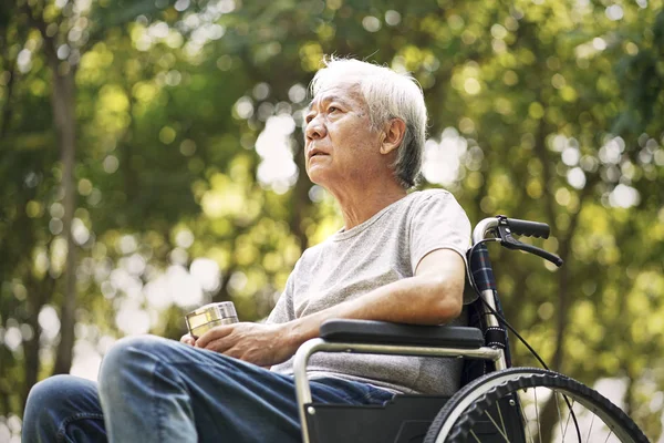 Asijský senior muž sedí na invalidním vozíku — Stock fotografie