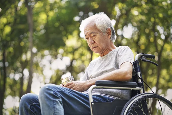 Asijský senior muž sedí na invalidním vozíku — Stock fotografie