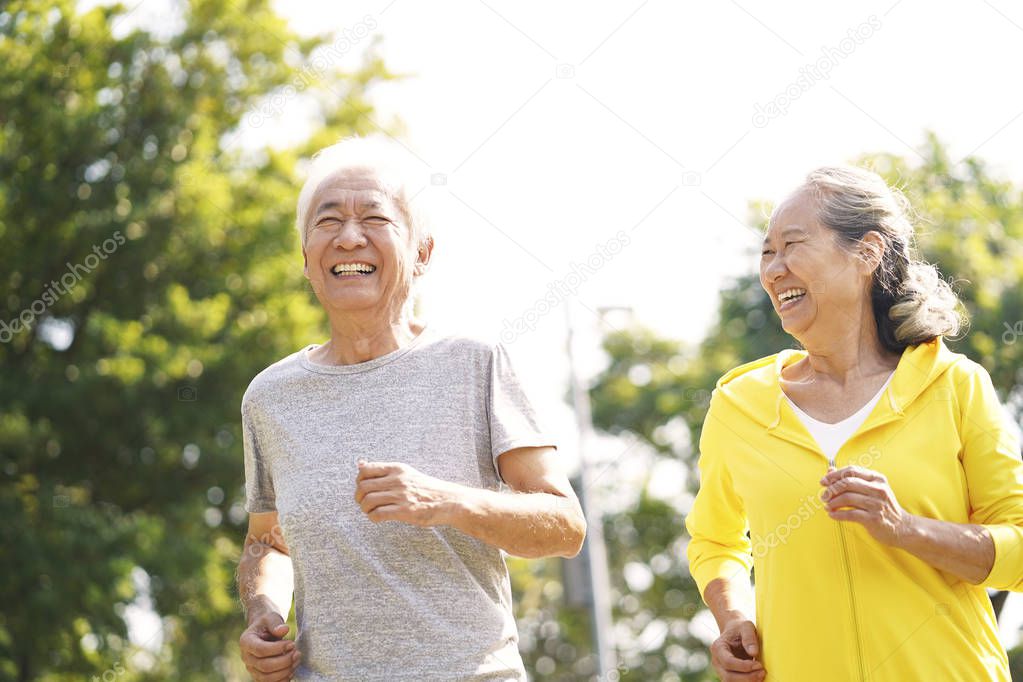 senior asian couple running in park
