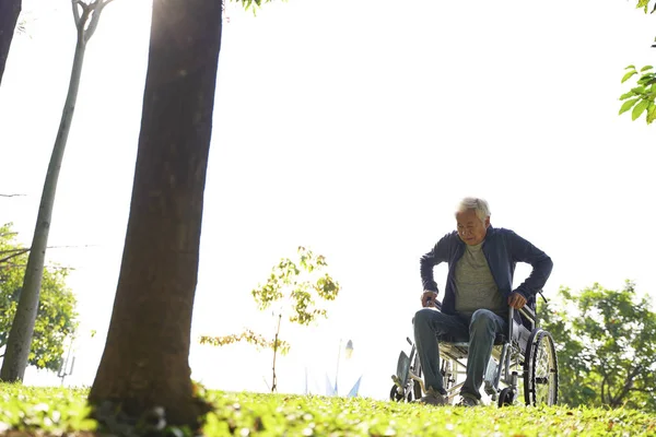 Asian old man trying to get up from wheelchair — Stock Photo, Image