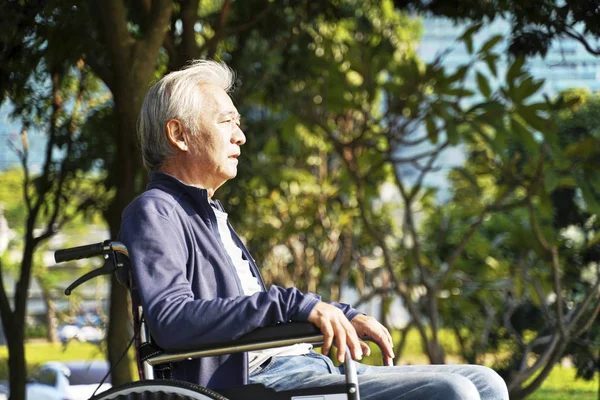 Asiático velho homem sentado em cadeira de rodas — Fotografia de Stock