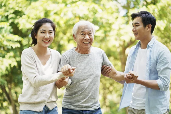 Young chinese couple spending time with father — Stock Photo, Image